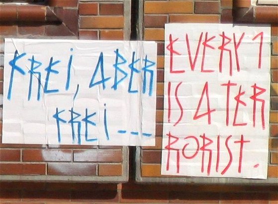 Schrift "Frei, aber frei..." und "Every 1 is a terrorist"