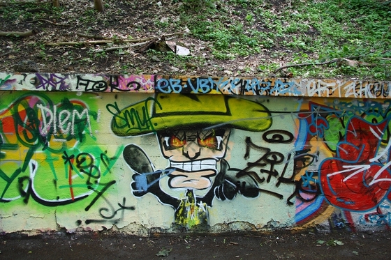 Graffito eines grinsenden Mannes mit Cowboyhut
