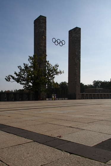 Eingangsbereich des Olympiastadions, zwei Türme mit einem knorrigen Baum davor