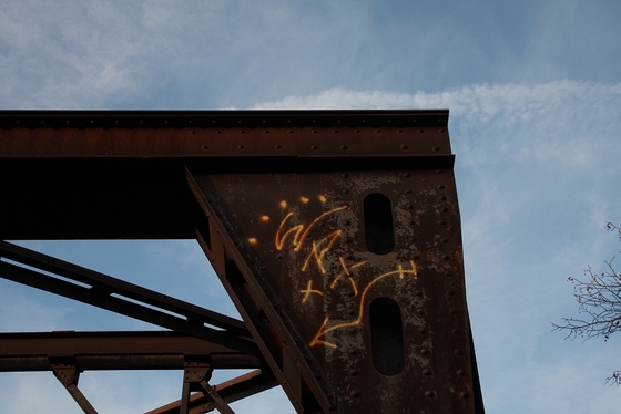 Ecke einer rostigen Stahlbrücke vor blauem Himmel