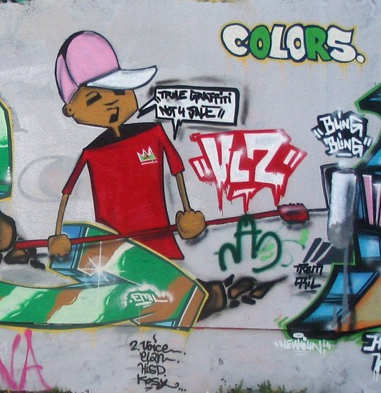 bemalte Hausfassade, Mann mit einer Farbrolle, Sprechblase "True Graffiti, not 4 sale"