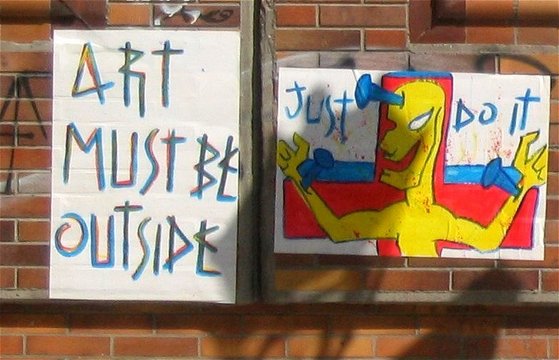 Schrift "Art must be outside" und ans Kreuz genagelte Figur "just do it"