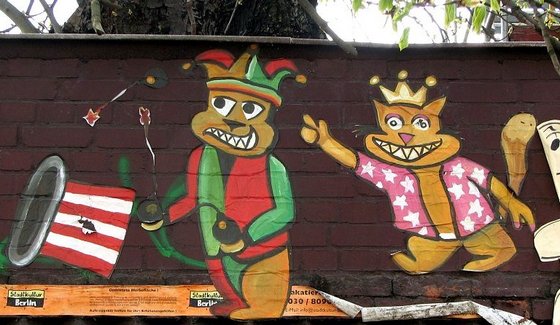 ein mit Bomben jonglierender Kater im Narrenkostüm und ein Königs-Kater im Hawaiihemd