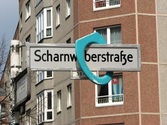 Toilettensitz auf dem Straßenschild "Scharnweberstraße"