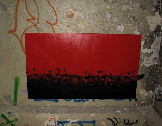 Silhouette einer demonstrierenden Menschenmasse vor rotem Hintergrund