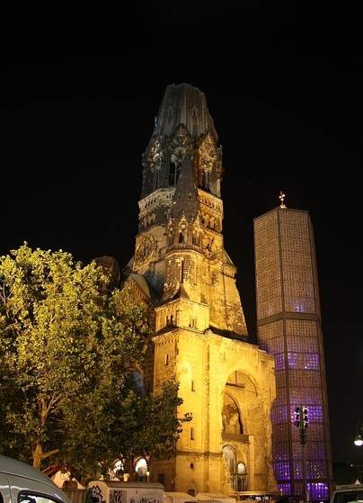 angestrahlte Gedächtniskirche mit einem Baum davor