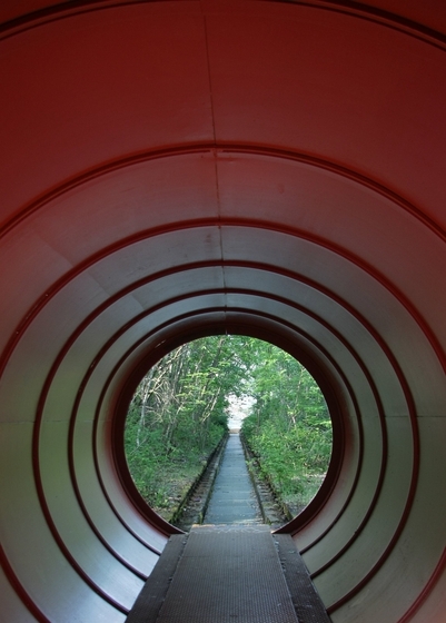 Blick entlang eines Weges aus einer Tunnelröhre hinaus