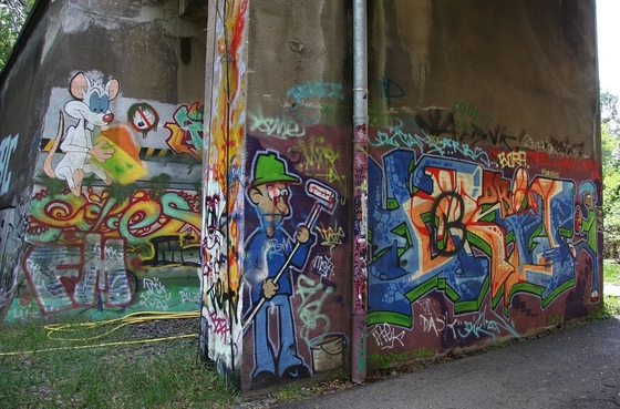 mit Graffiti verzierter Durchgang, unter anderem mit einem Maler und Pinky