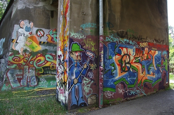 mit Graffiti verzierter Durchgang, unter anderem mit einem Maler und Pinky