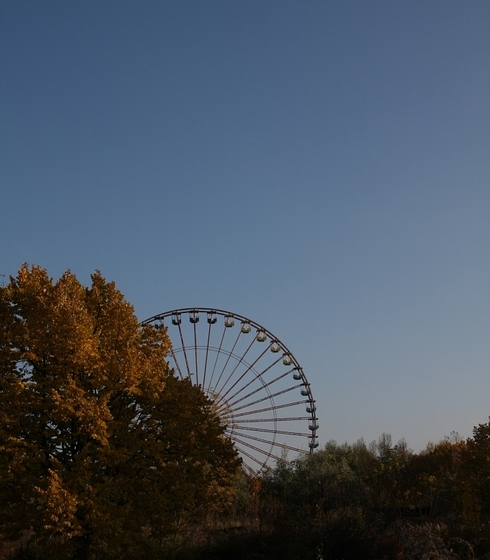 Riesenrad, teilweise von einem herbstlich gefärbten Laubbaum verdeckt