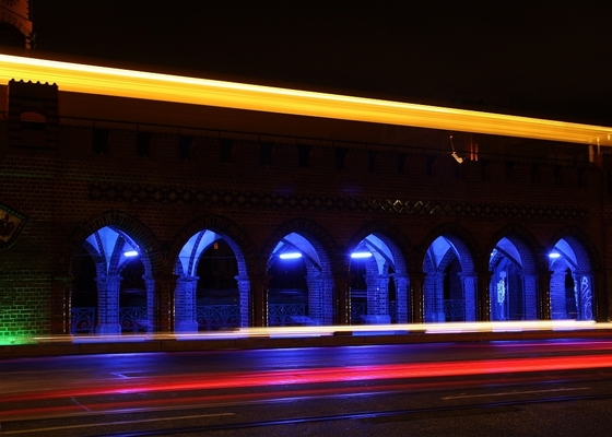 Oberbaubrücke bei Nacht mit Lichtschleiern vorbeifahrender Autos und der U-Bahn