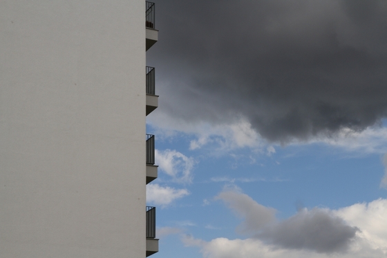 Seitenfassade eines Wohnhauses, Balkone vor Wolkenkulisse
