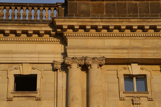 sonnenbeschienene Hausfassade, ein offenes und ein geschlossenes Fenster