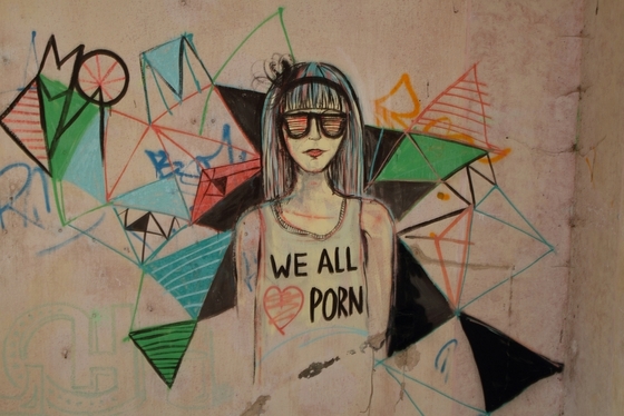 Wandmalerei: Mädchen mit Sonnenbrille, Shirt-Beschriftung "We all love porn"