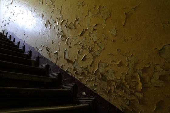 Stufen einer Holztreppe, Wand von der Farbe abblättert