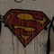 Mann malt sich das Superman-Symbol auf die Brust