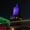 Langzeitbelichtung der bunt angestrahlten Oberbaumbrücke, Mond zwischen den Türmen