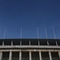 Frontalaufnahme des oberen Bereichs des Olympiastadions vor blauem Himmel