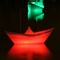bunt beleuchtete Falt-Schiffchen auf einer Wasserfläche