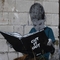 Wandmalerei: kleiner Junge liest Banksys Buch "Cut it out"