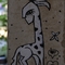 bemalte Säule: stilisierte Giraffe mit drei Vögeln auf dem Kopf
