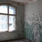 durch ein Fenster beleuchteter Raum, Farbe blättert von der Wand